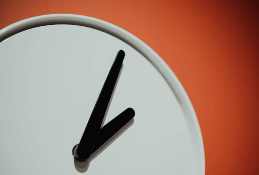 White clock on an orange wall