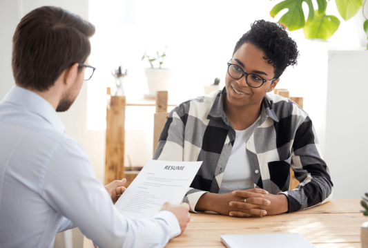 Two people in an interview going over a resume